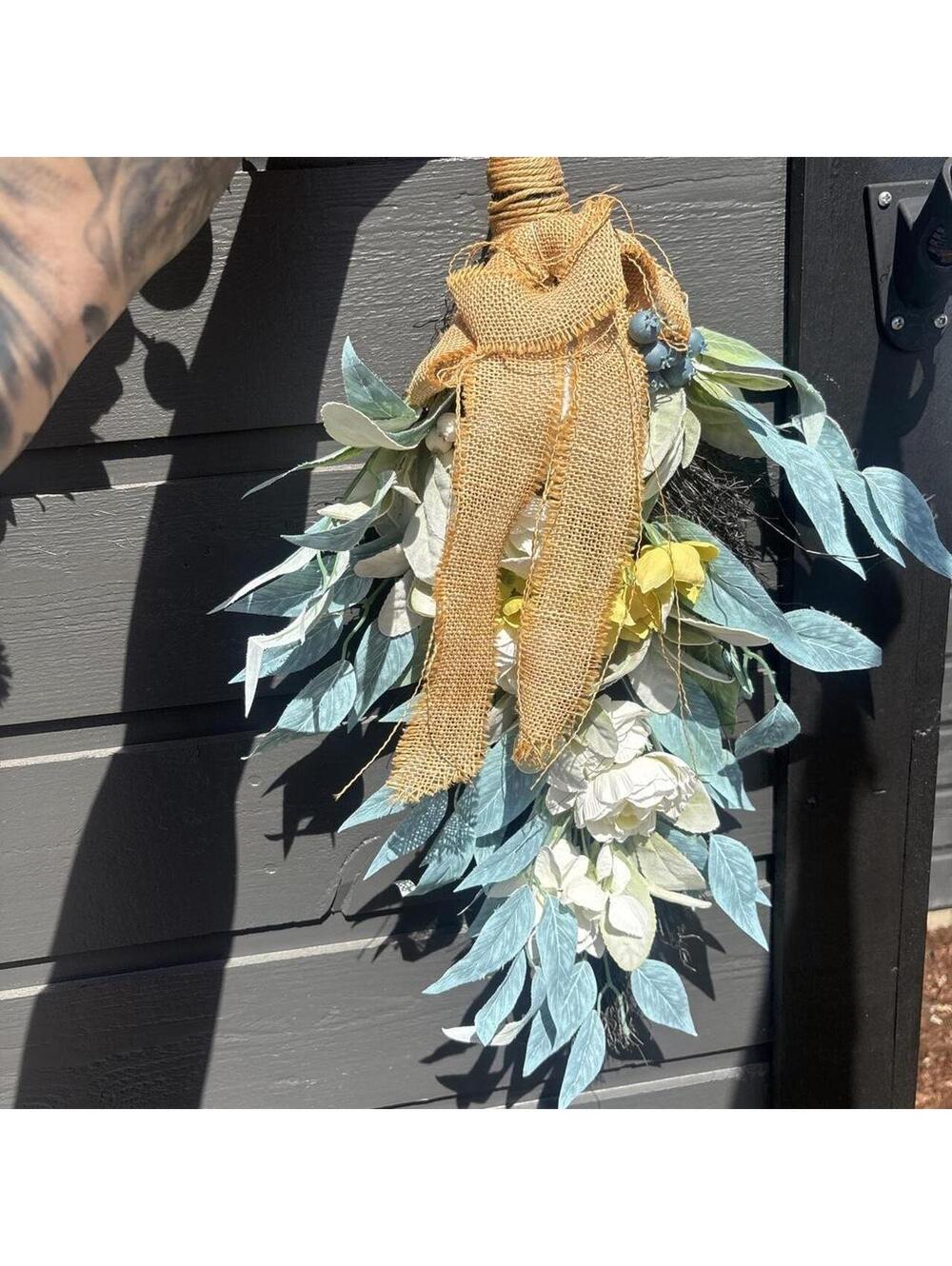 Yellow and blue floral wreath with burlap ribbon and white flowers